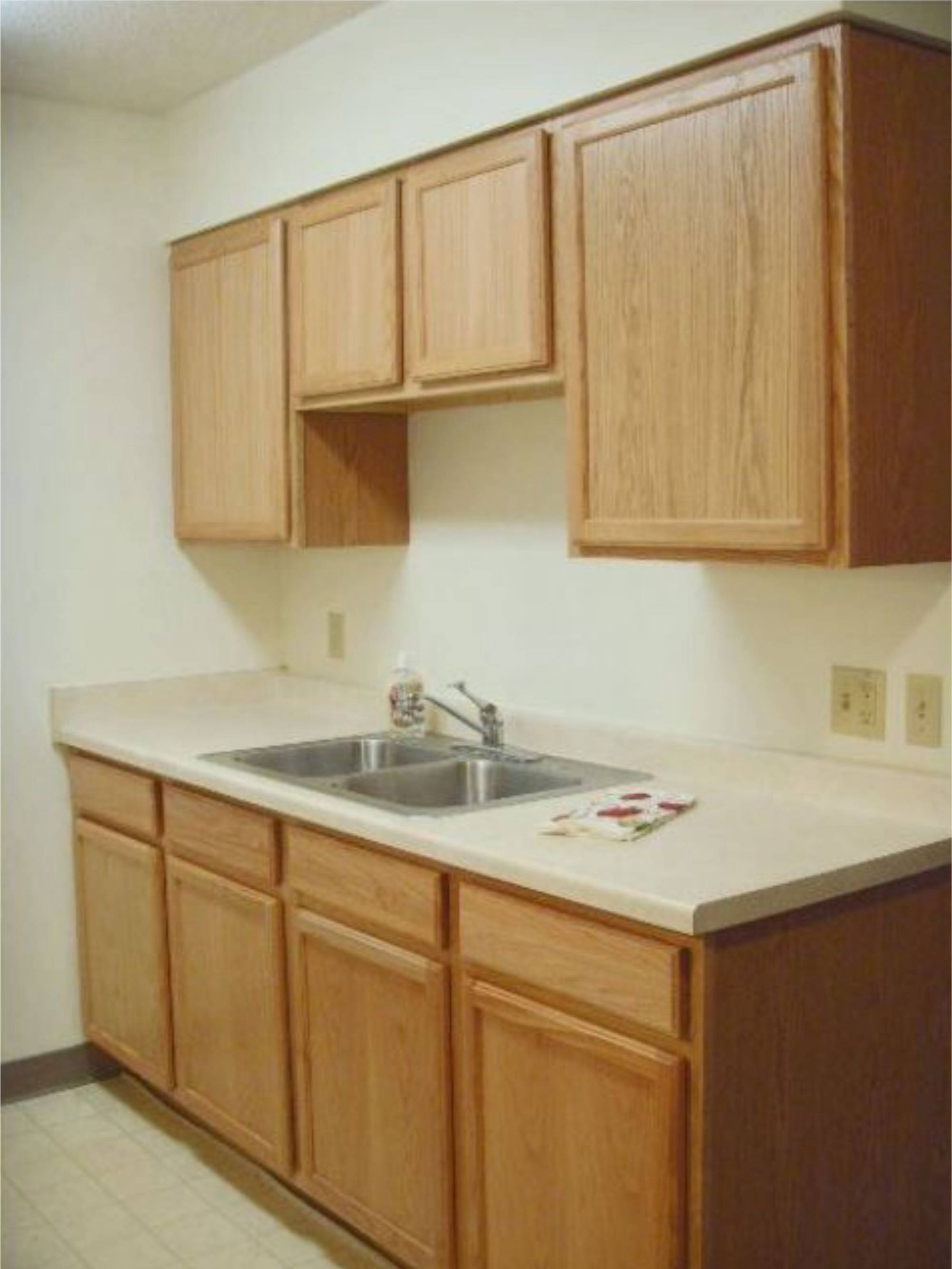 Right side of kitchen showing sink and cabinets above and below sink. Fairview Apartments St Peter, MN